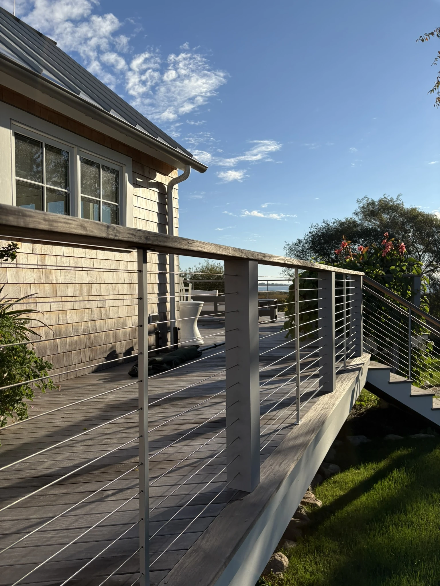 Deck with stainless cable railing overlooking open fields in Little Compton